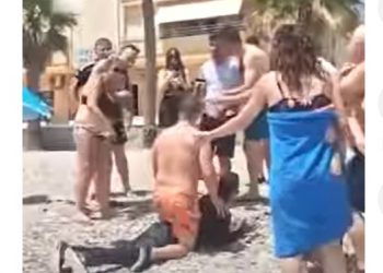 Imágenes de inmigrantes desesperados llegando a una playa y bañistas deteniéndolos